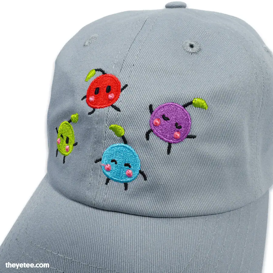 Light gray baseball cap with colorful embroidered game characters, perfect for cozy gaming fans.